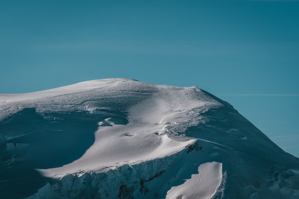 a mountain covered in snow under a blue sky