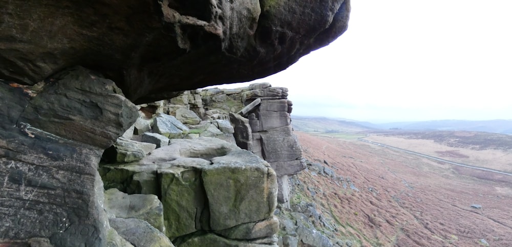 a rocky cliff with a large rock formation on top of it