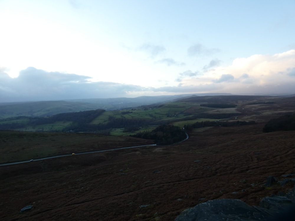 a view of a grassy field with hills in the distance