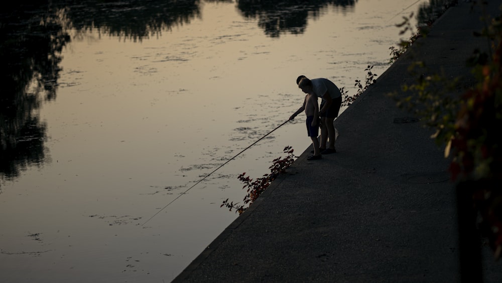 a man standing next to a body of water