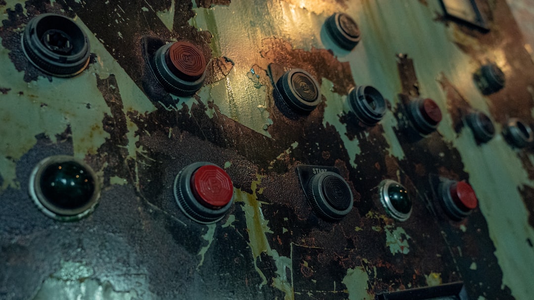 professional 掃除機 コードレス 充電できない a close up of a metal surface with red and black knobs