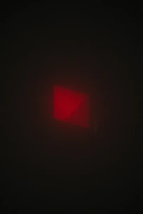 Dark, gritty close-up of a blood-red email icon glowing against a black background.