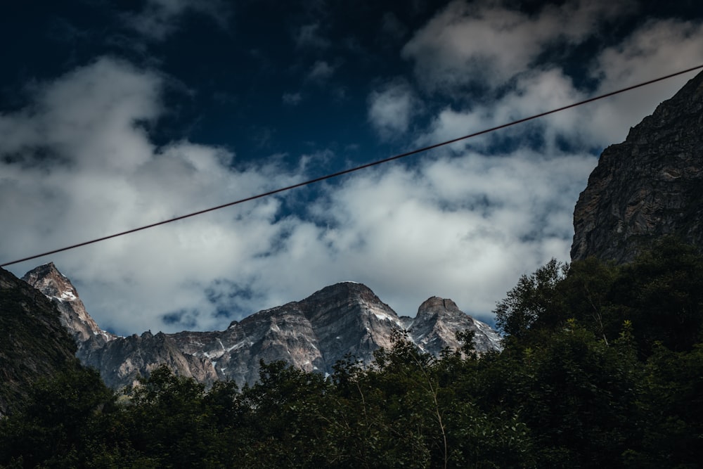a rope in front of a mountain range under a cloudy sky