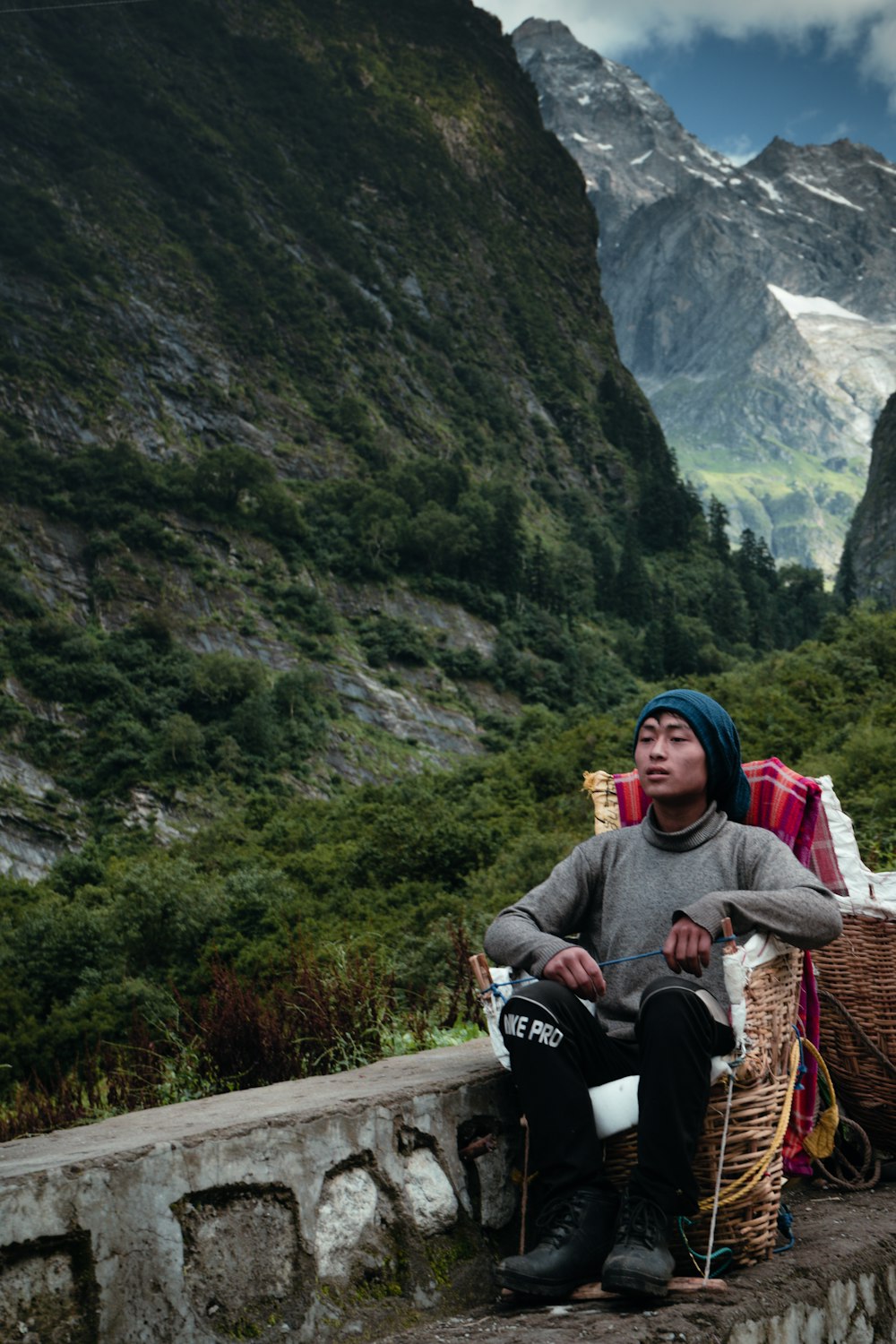 a man sitting on a wall next to a mountain