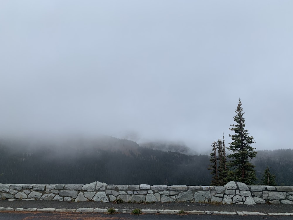 a stone wall with a mountain in the background