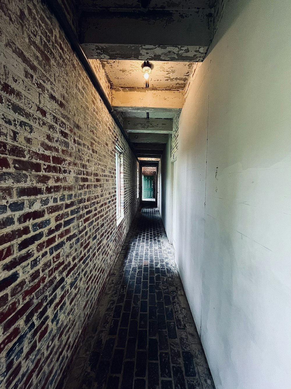 a long narrow hallway with a brick wall