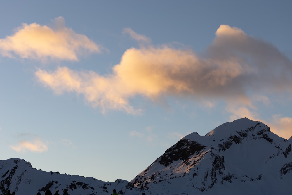 Una montaña cubierta de nieve con una nube en el cielo
