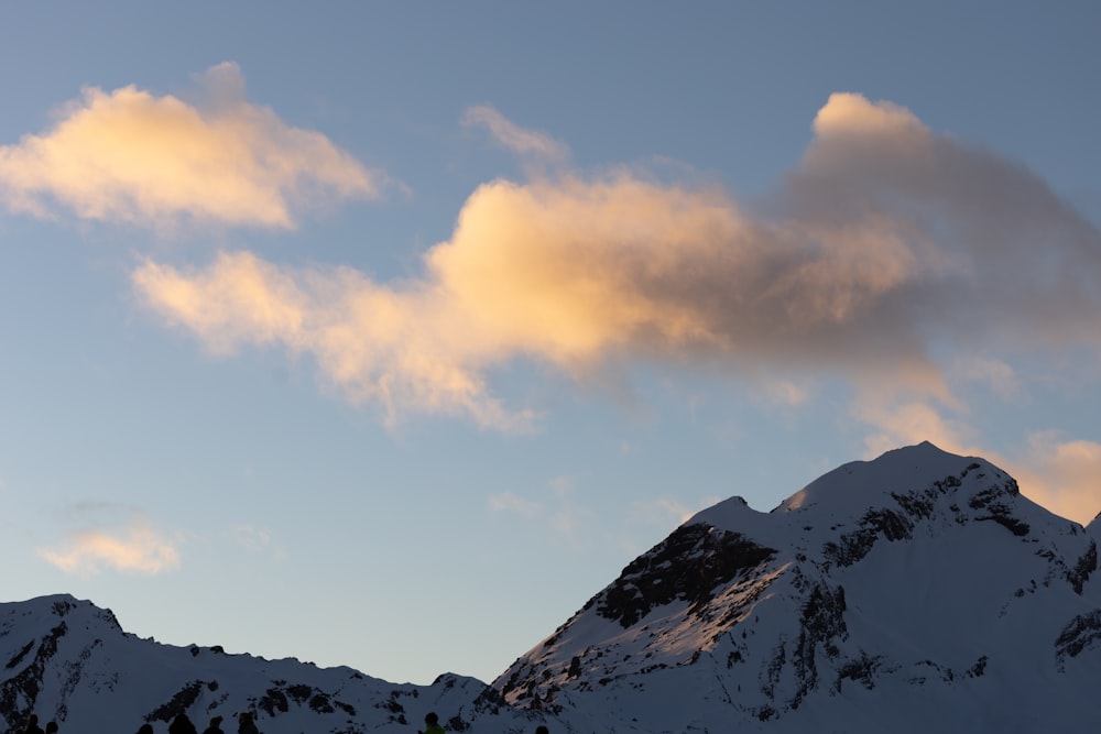 空に雲が降る雪に覆われた山