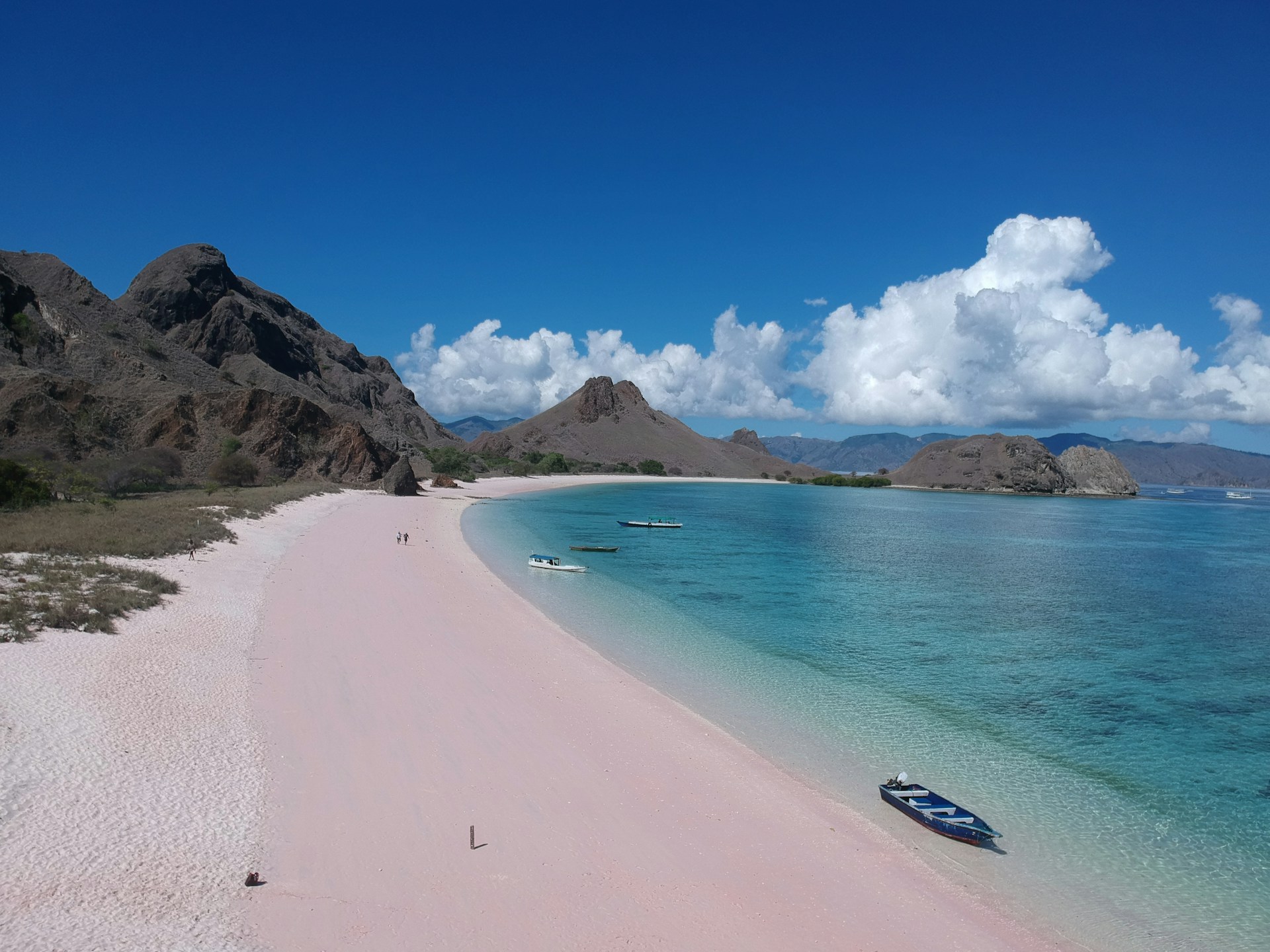 a boat is sitting on a pink beach