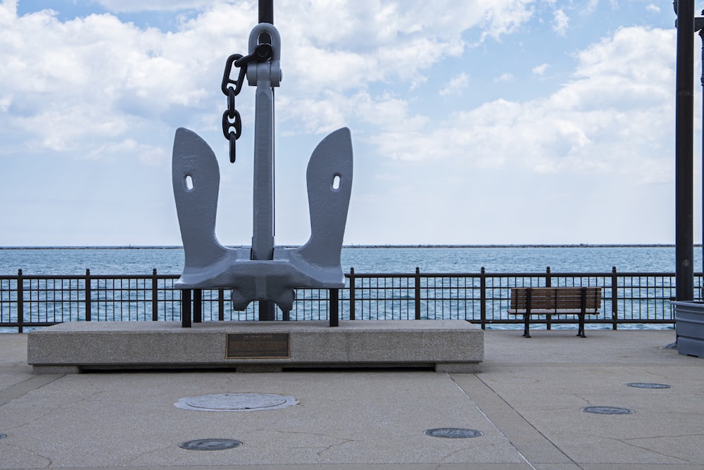 uma grande escultura de metal sentada em cima de uma calçada