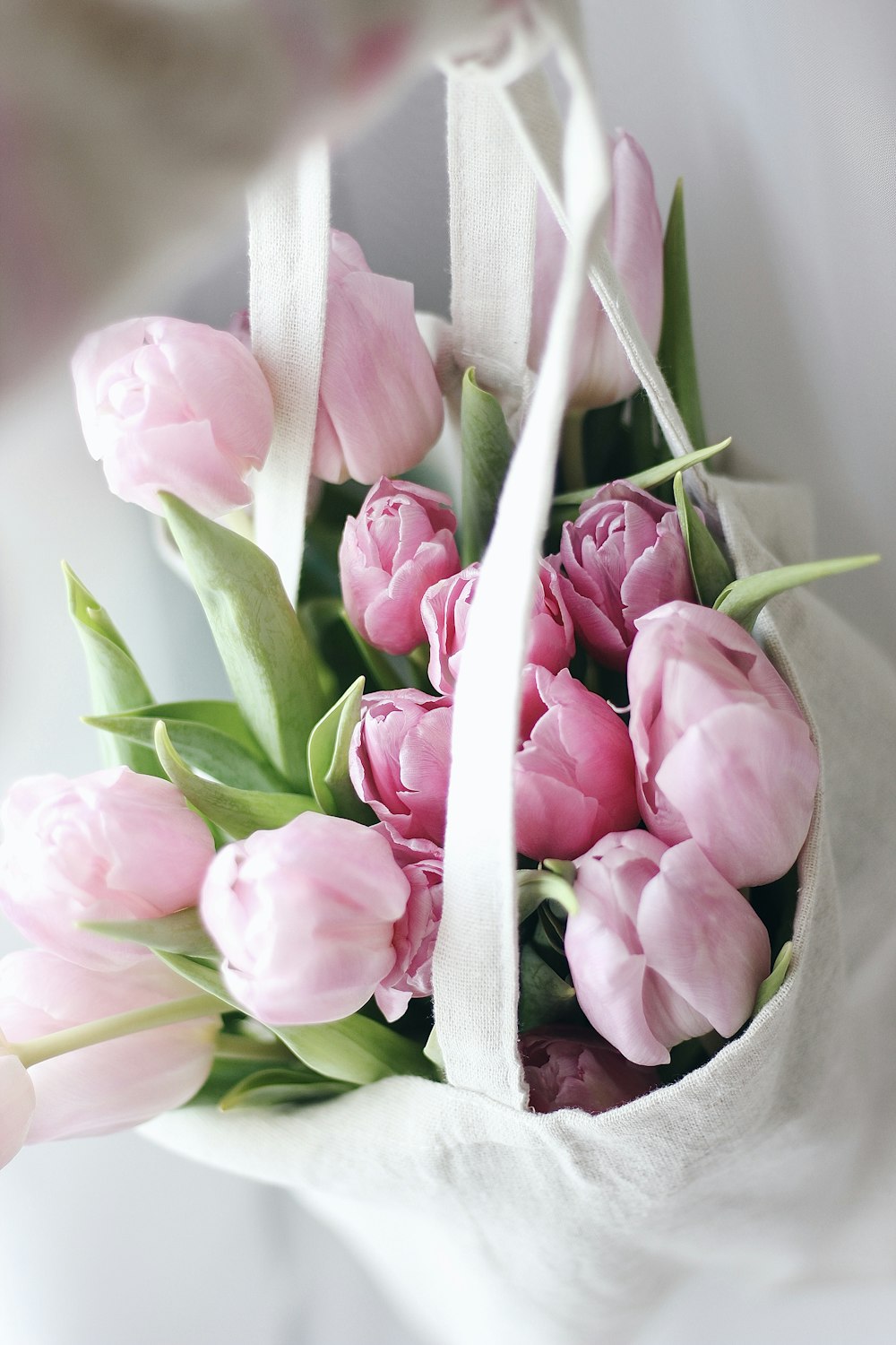 a bouquet of pink tulips wrapped in white paper