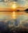 A serene sunset over a tranquil beach, symbolizing peace and reflection.