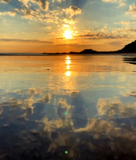 A serene sunset over a tranquil beach, symbolizing peace and reflection.