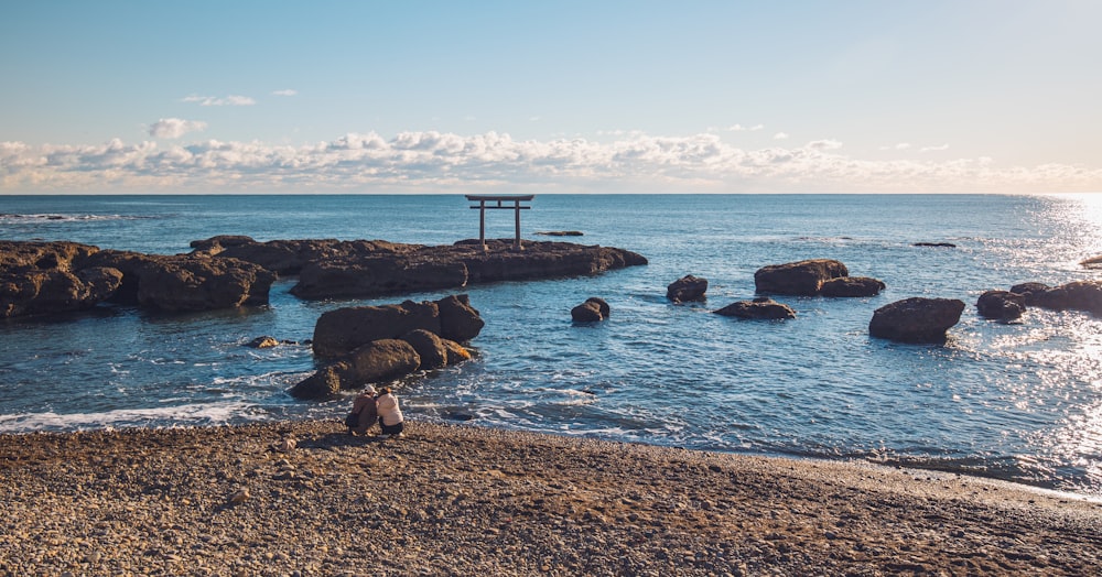 海の隣のビーチに座っている人