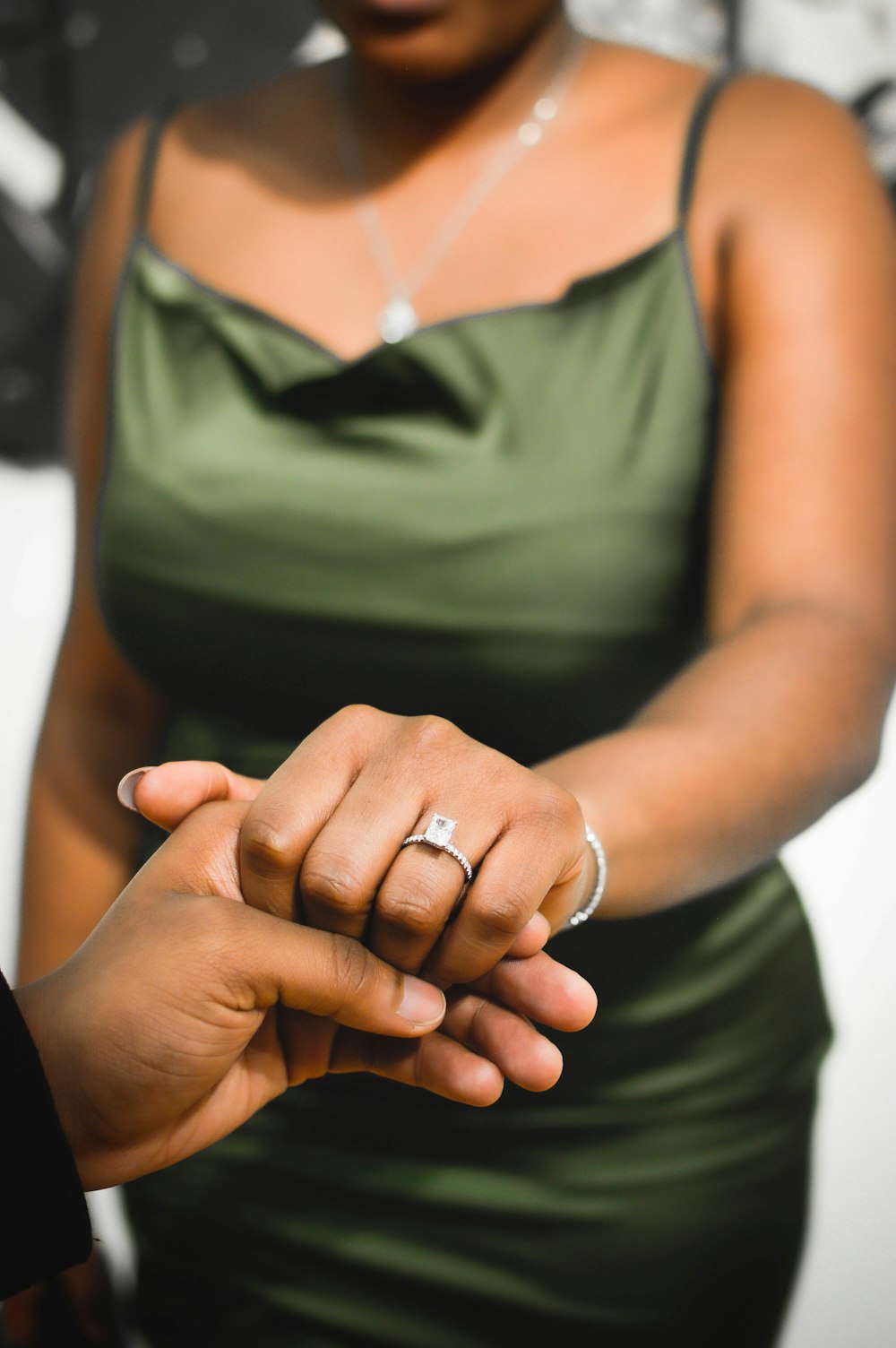 a woman holding the hand of a man in a green dress