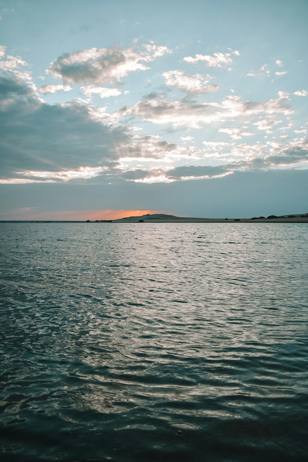 a large body of water under a cloudy sky