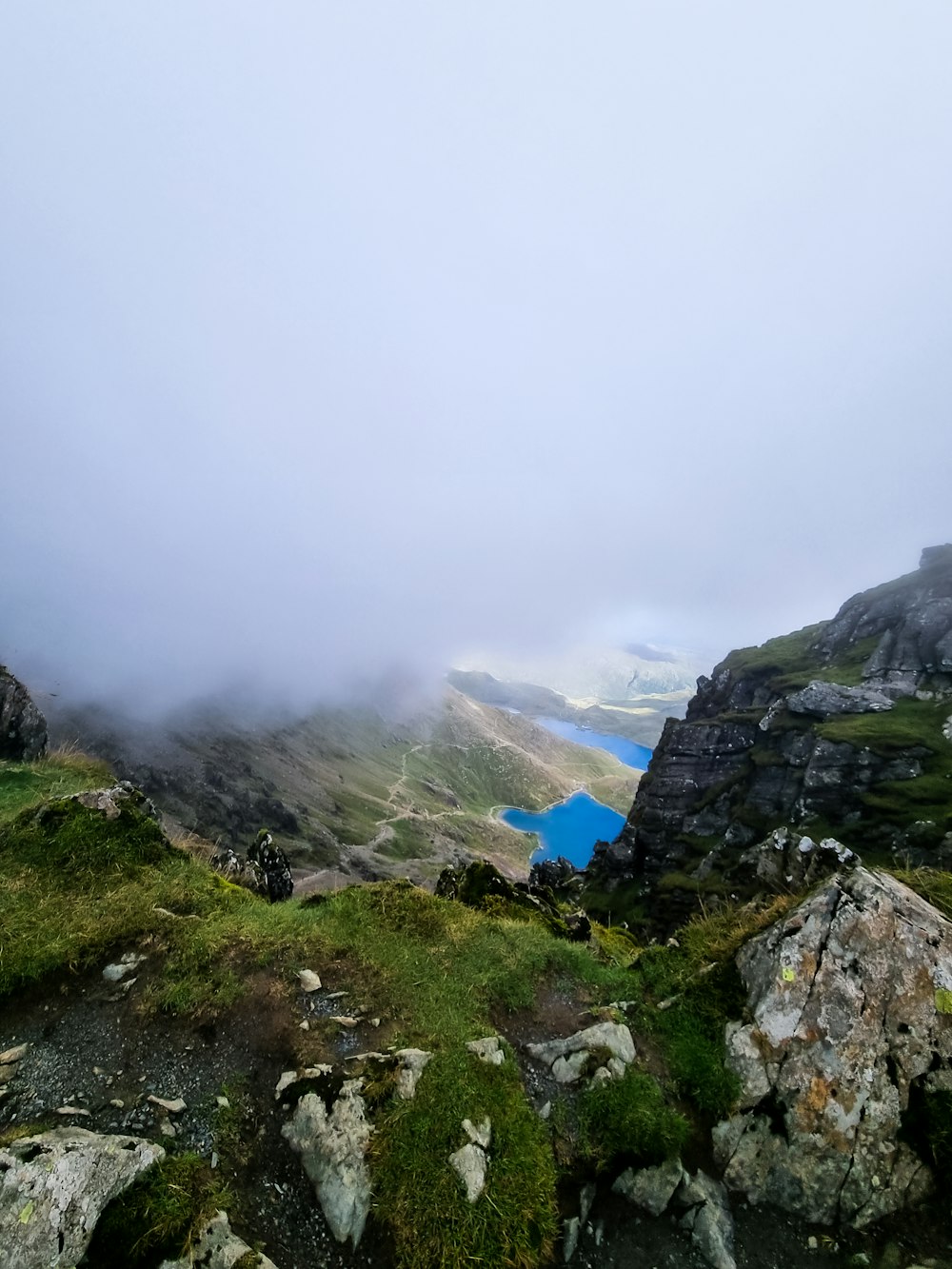 a foggy mountain with a lake in the distance