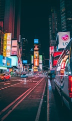 A vibrant mobile digital LED sign mounted on a truck driving through a busy city street.