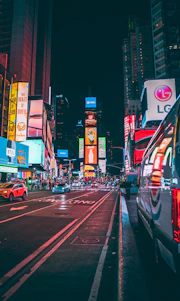 A vibrant city street in Vancouver featuring a large LED advertising board displaying colorful digital ads.