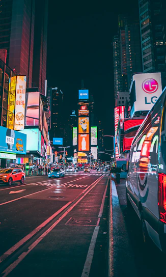 A vibrant city street in Vancouver featuring a large LED advertising board displaying colorful digital ads.