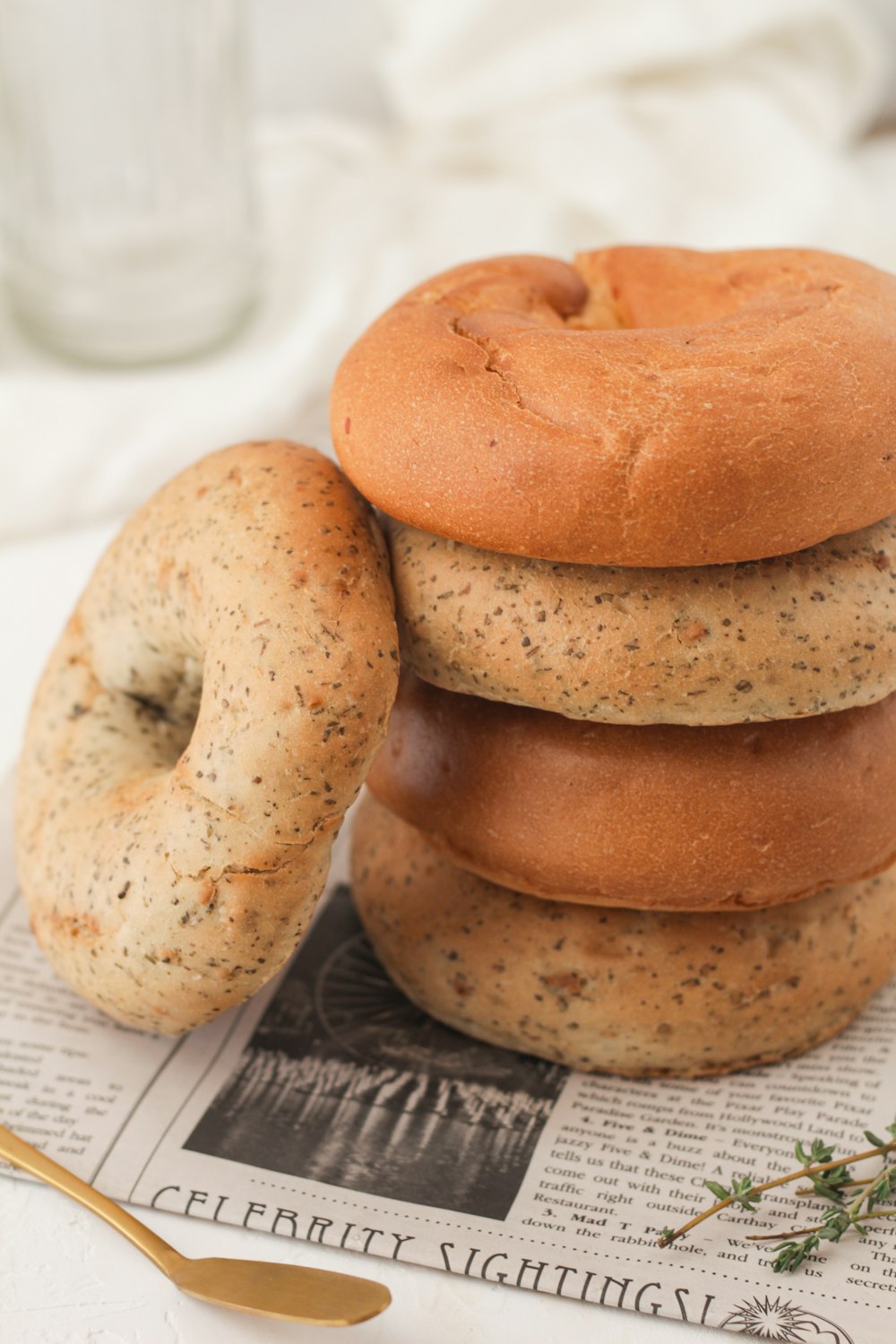 a stack of bagels sitting on top of a newspaper