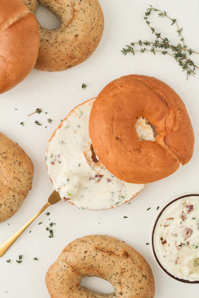 Table topped with bagels covered in cream cheese, a New York appetizing spread