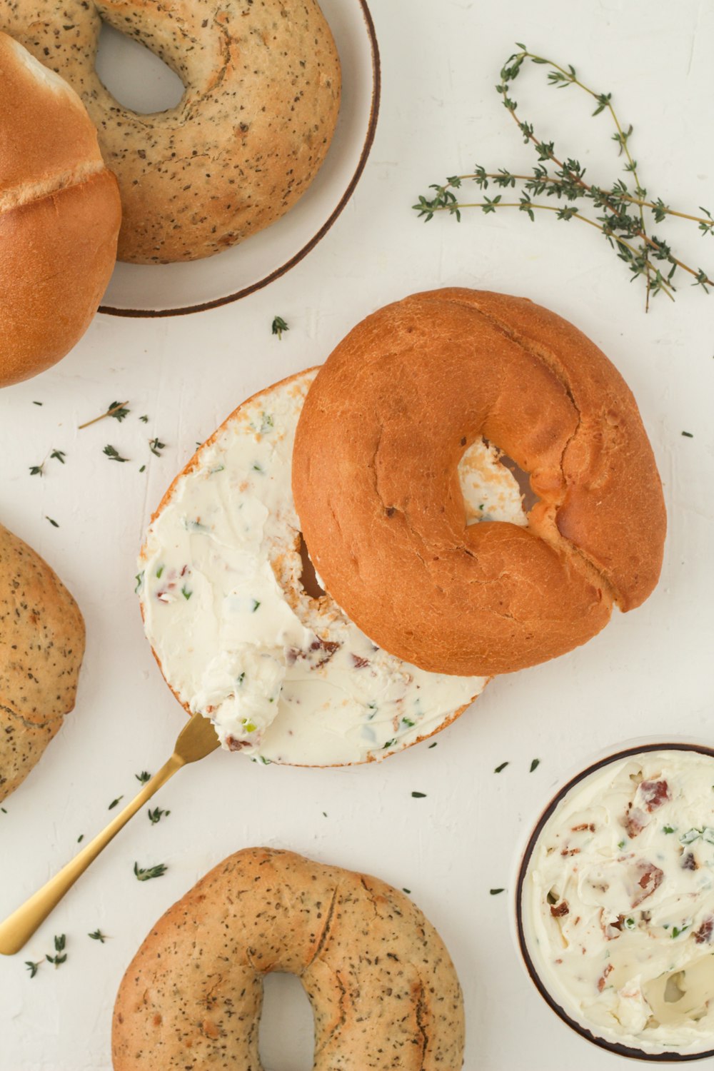 a table topped with bagels covered in cream cheese