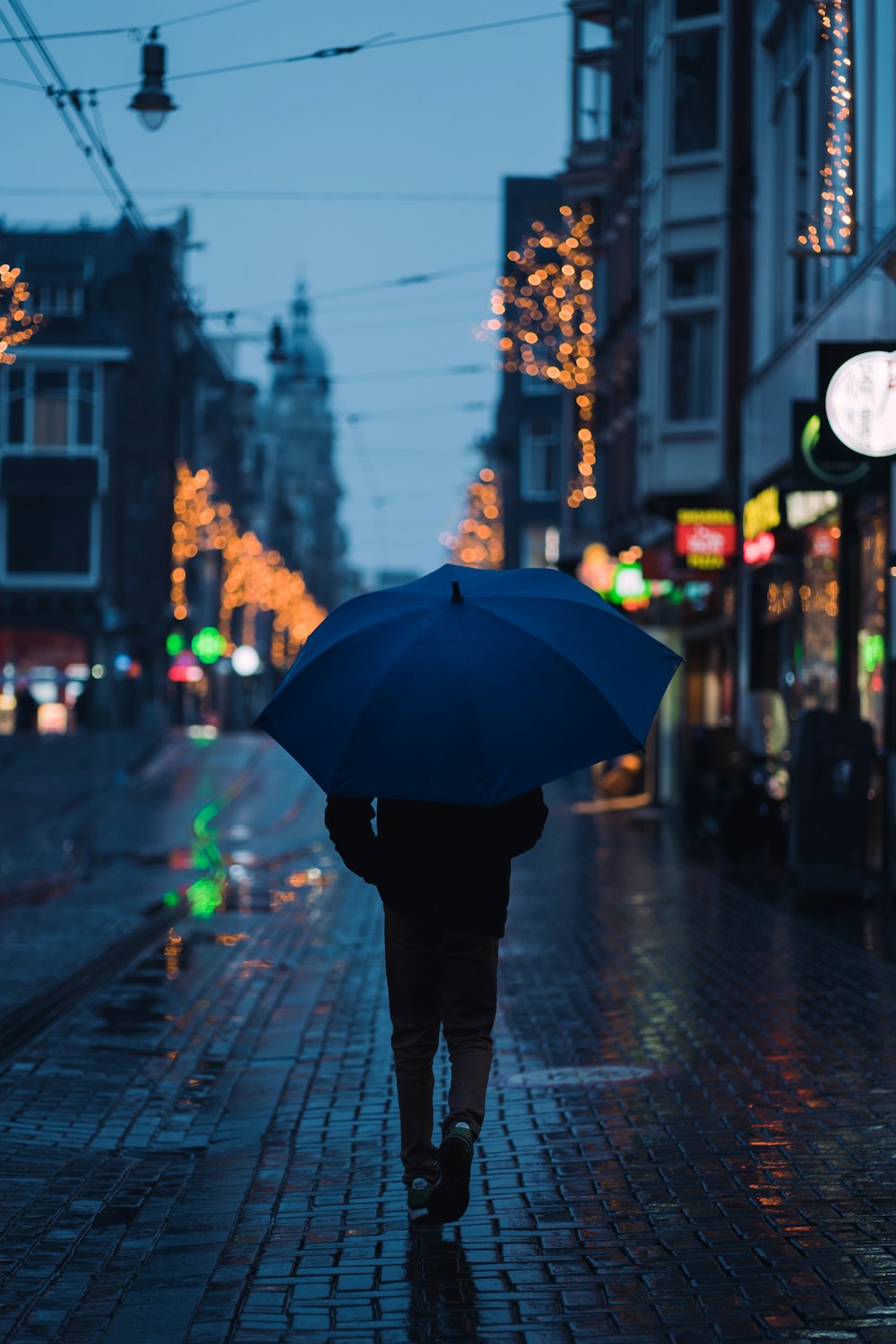 a person walking down a street holding an umbrella