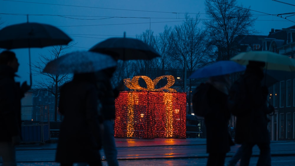 a group of people walking down a street holding umbrellas