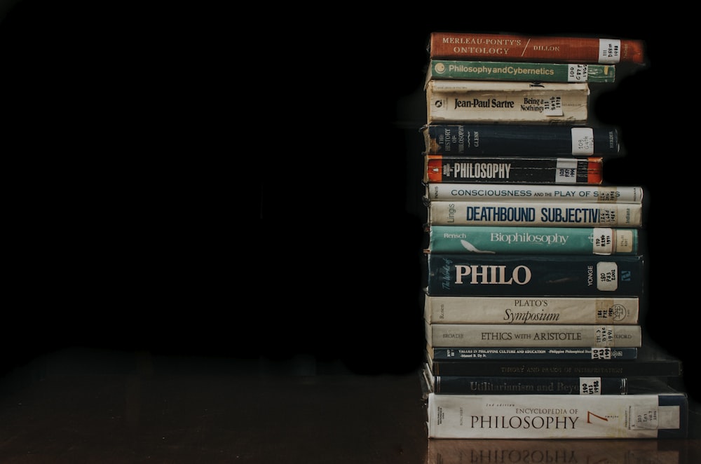 a stack of books sitting on top of a wooden table