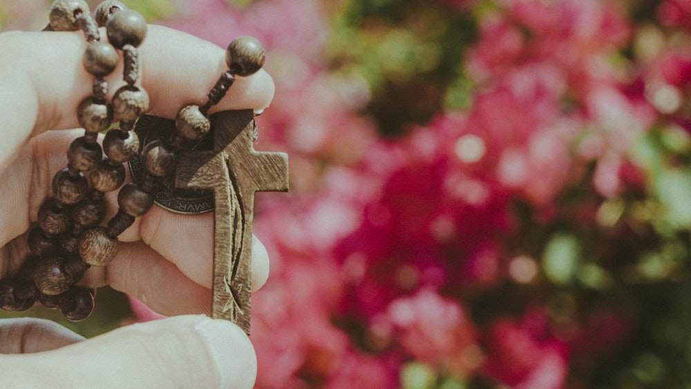 una persona che tiene un rosario in mano