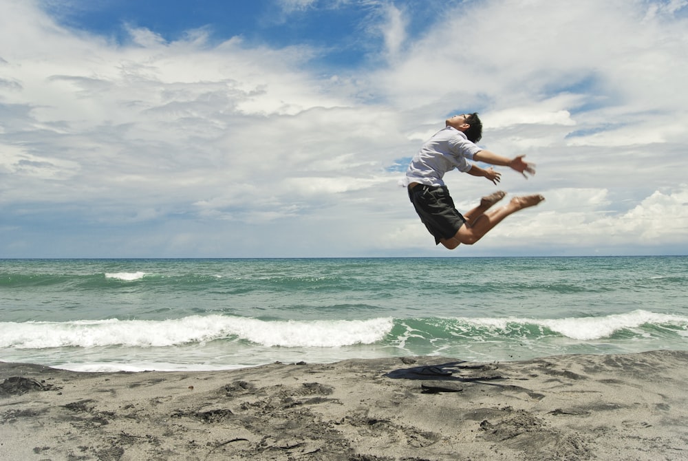 a man jumping into the air on a beach