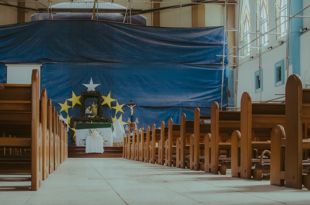 Una iglesia con filas de bancos y una bandera envuelta en el fondo