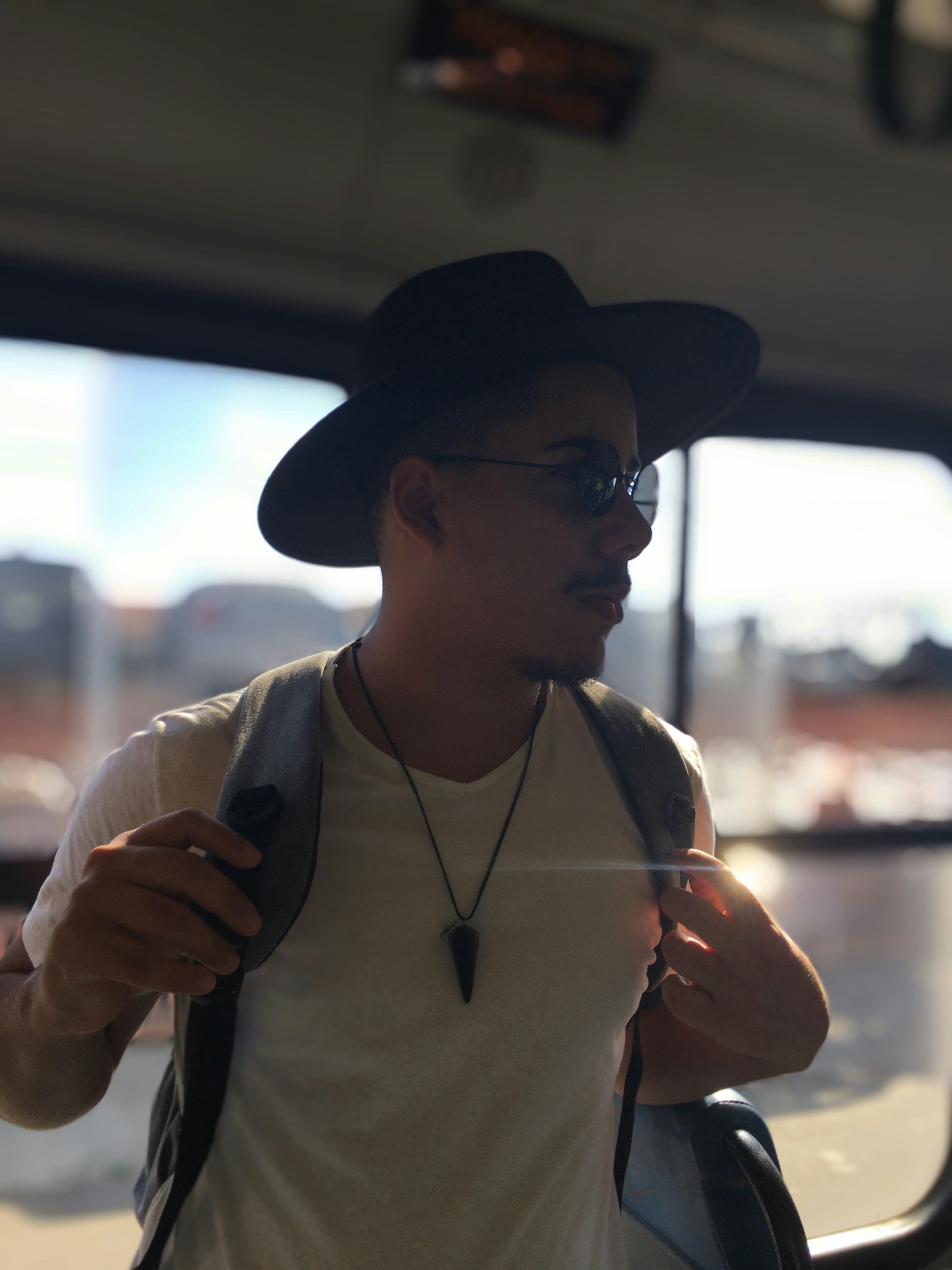 Ein Mann mit Hut und Brille steht in einem Bus