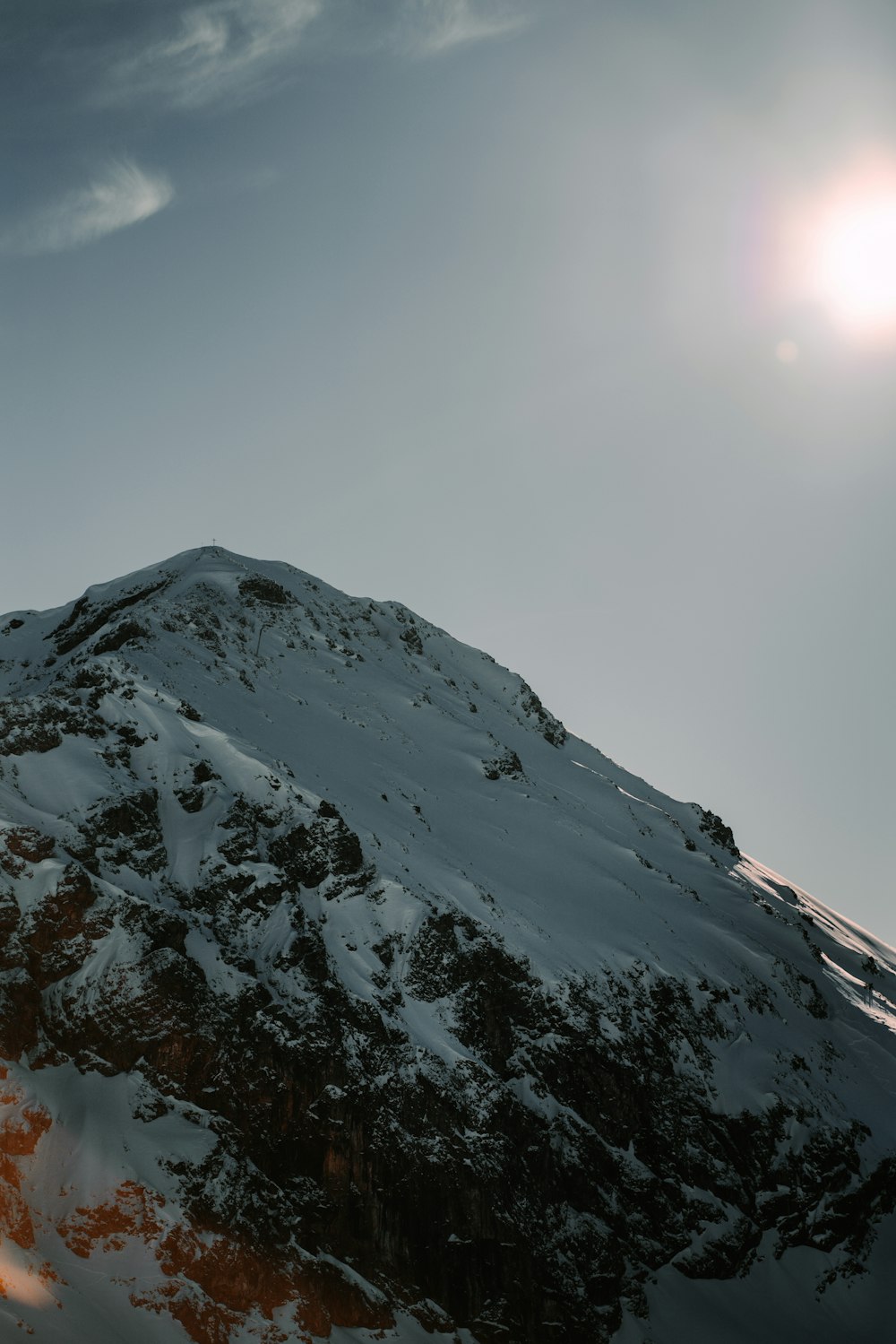 a snow covered mountain under a cloudy sky