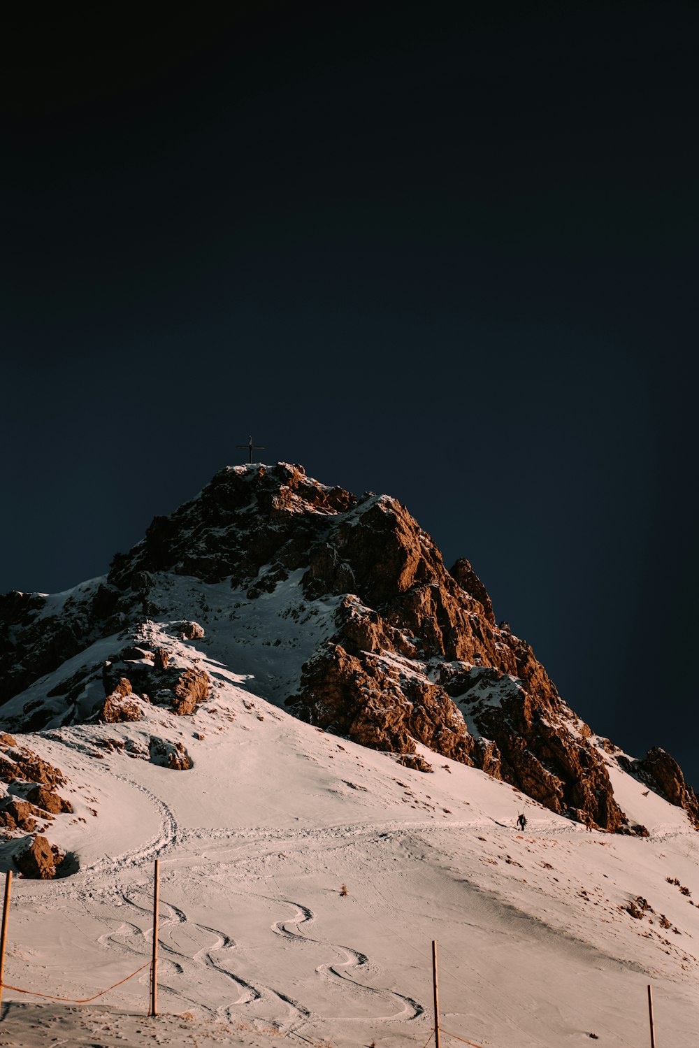 a snow covered mountain with tracks in the snow