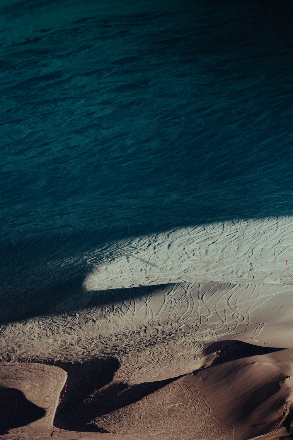 a person riding a surfboard on top of a sandy beach