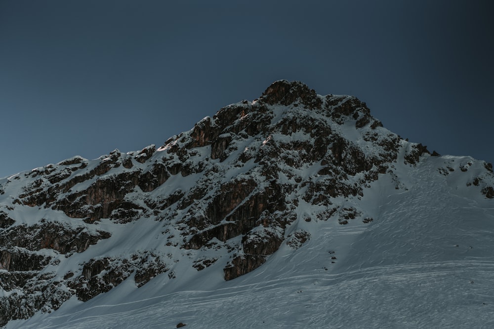 a mountain covered in snow under a blue sky