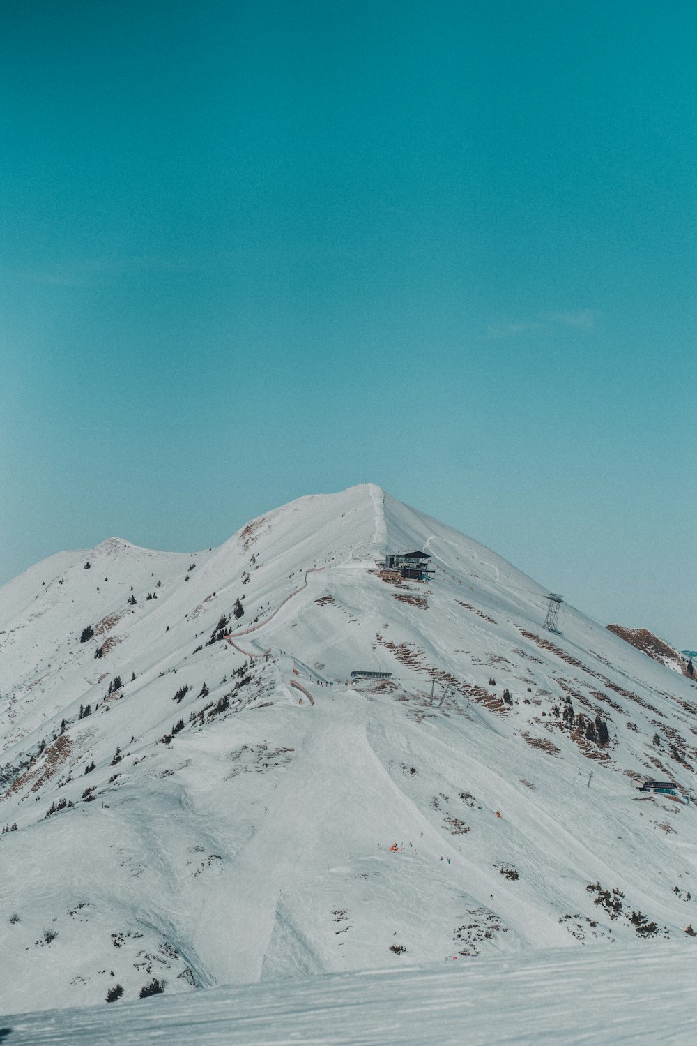 a snow covered mountain with a ski lift in the distance