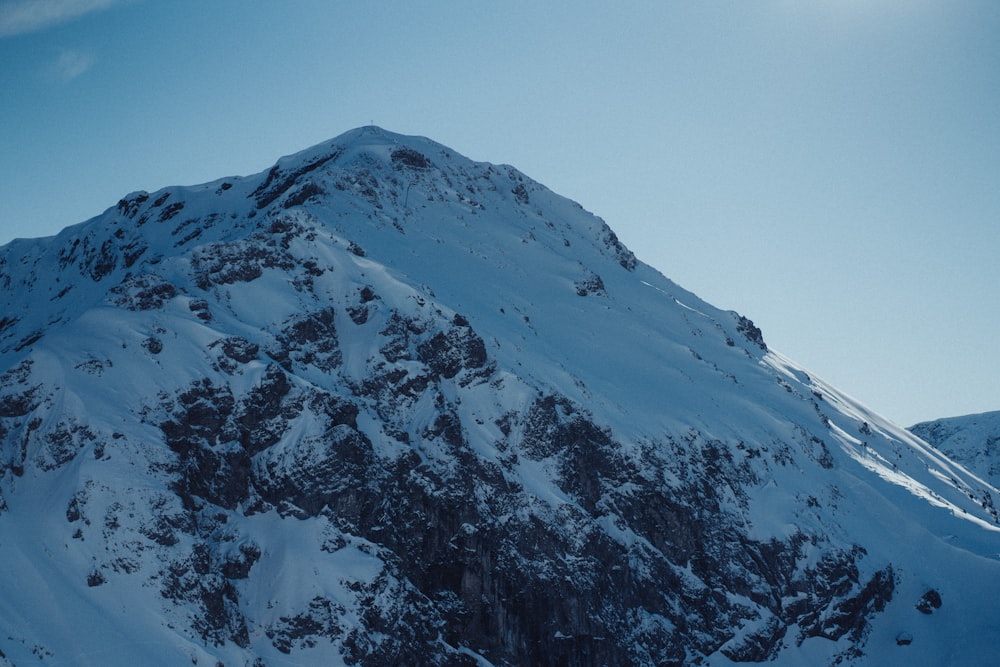 a mountain covered in snow under a blue sky