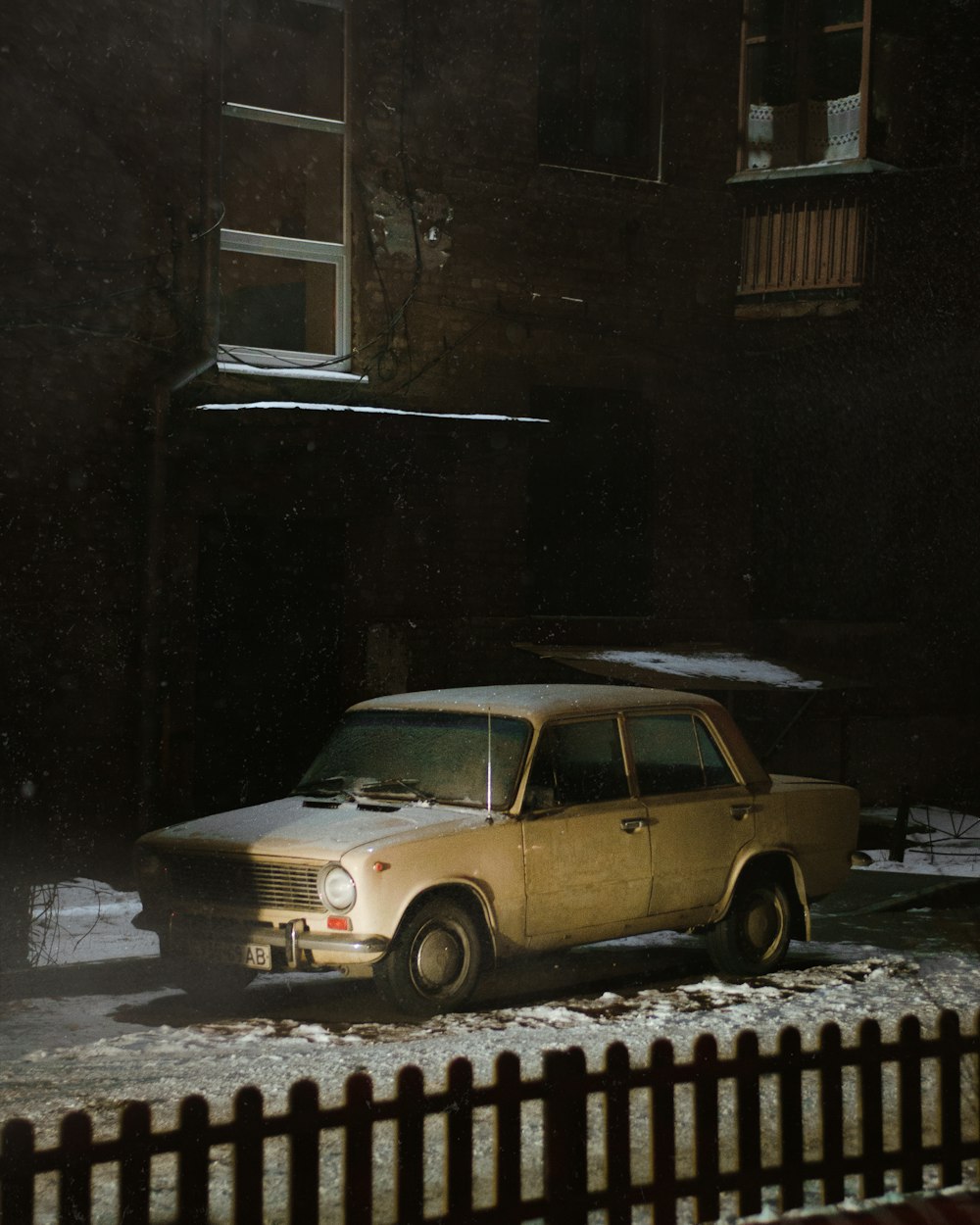 a car parked in front of a building in the snow