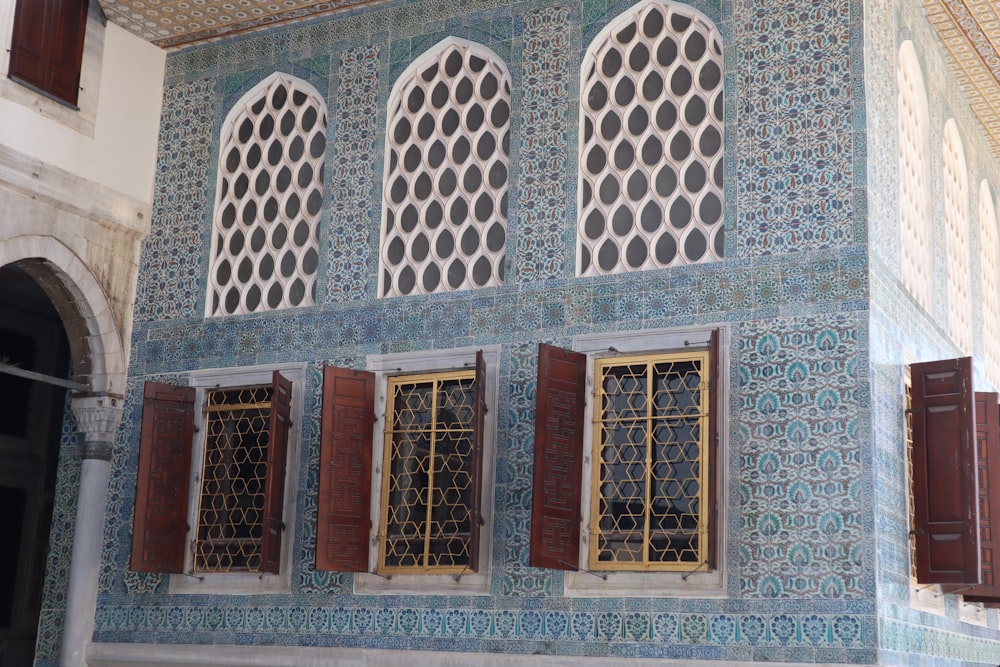 a blue building with three windows and shutters