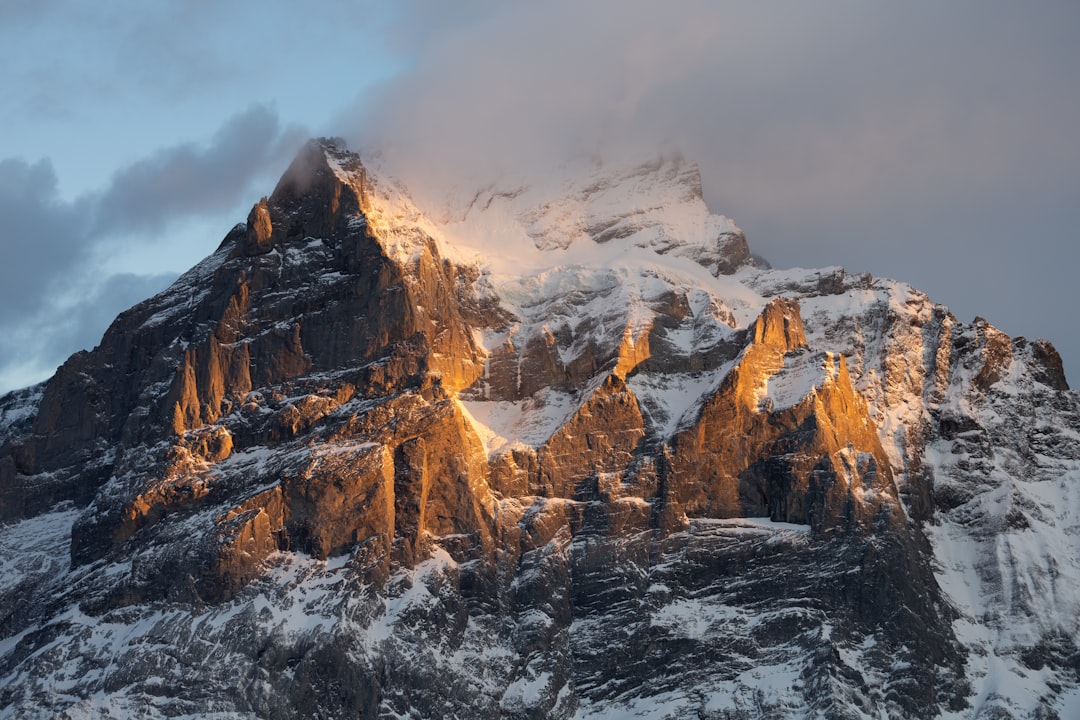 a mountain covered in snow with a sky background,