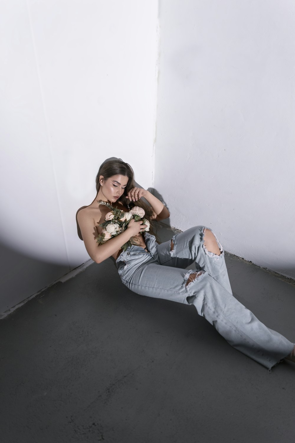 a woman sitting on the floor with a bouquet of flowers