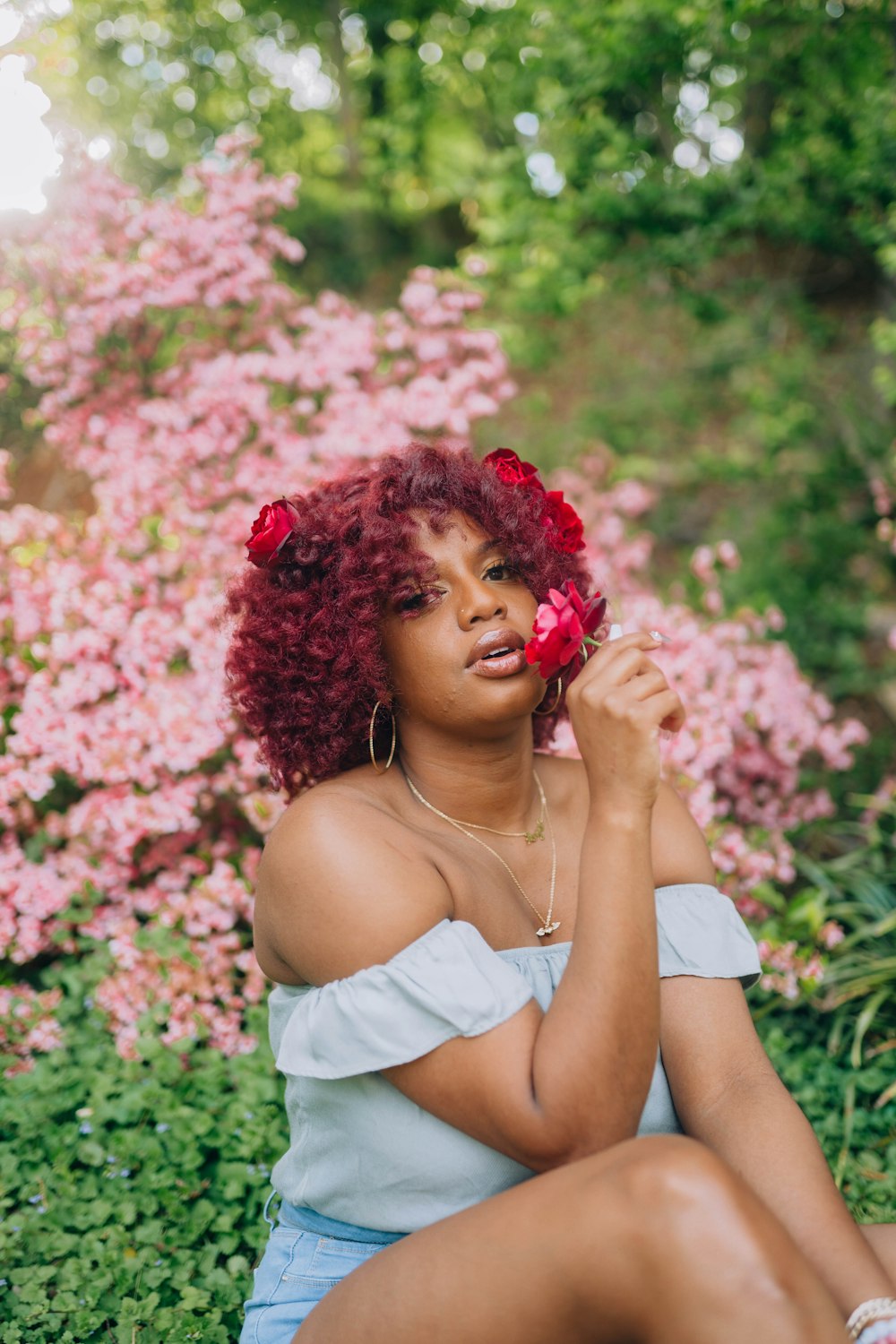 a woman with red hair sitting on the ground