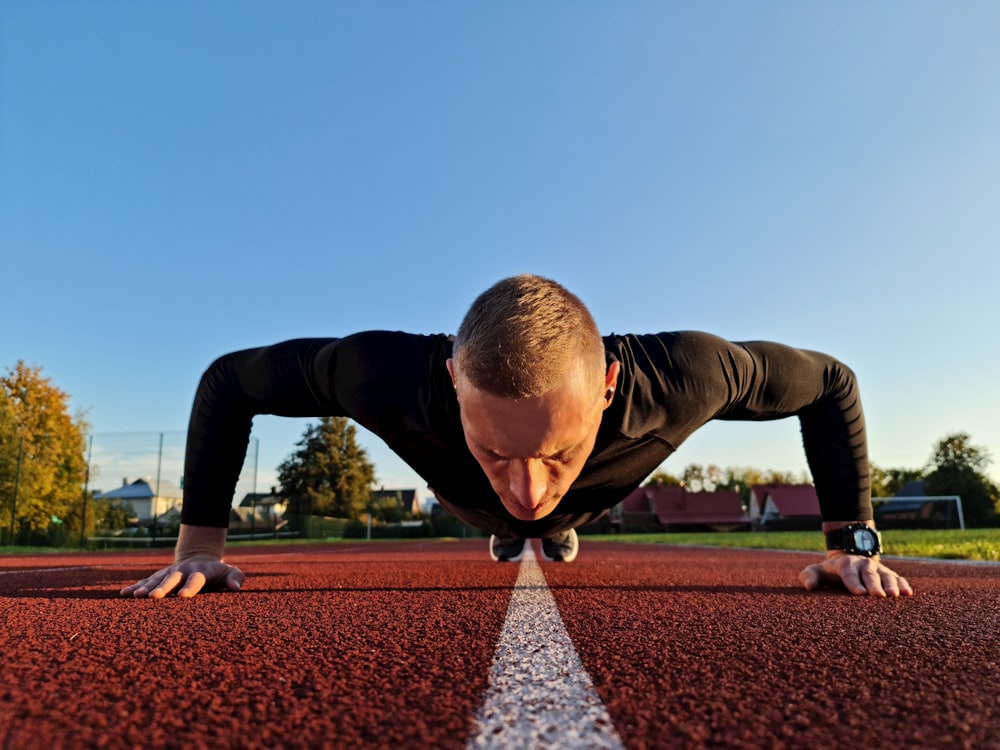 a man is doing push ups on a track