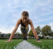 a woman is doing push ups in the grass