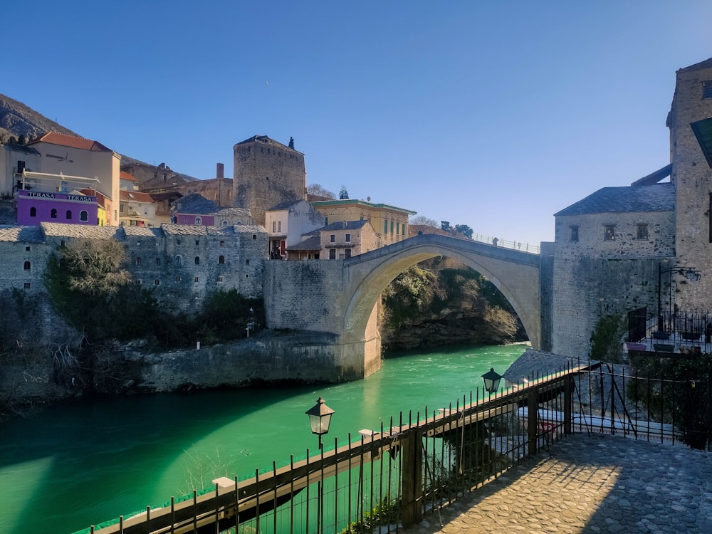 Eine Brücke über einen grünen Fluss in einer Stadt