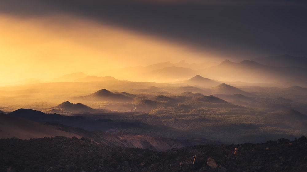 the sun is shining through the clouds over the mountains