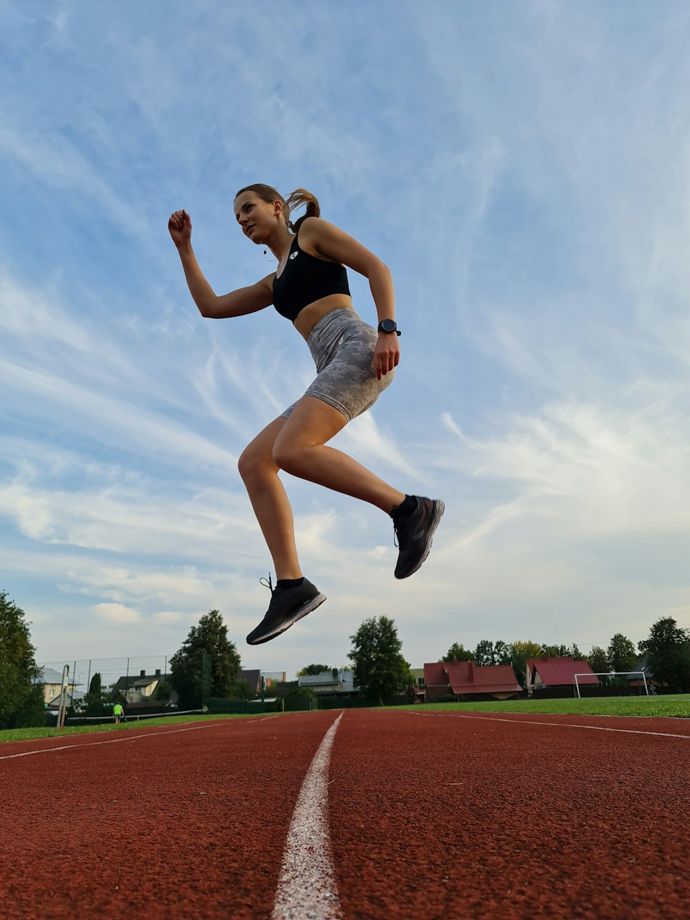 a woman is jumping in the air on a track